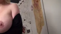 Blonde Frau mit großen Brüsten in schwarzem Top, Wand mit Comic-Strip