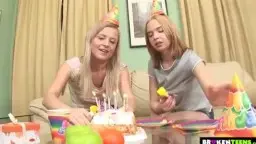 Zwei blonde Teens mit Partyhütchen am Geburtstagstisch