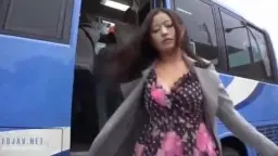 Asiatische Frau in heller Bluse steht im Bus