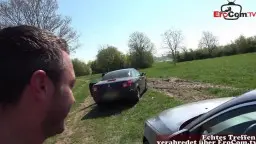 Frau kniet auf Kies, leckt Schwanz von hinten