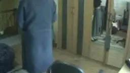 Mann und Frau vor Kleiderschrank, sie kniet, er nackt, Spiegelbild