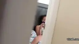 Frau liegt mit gespreizten Beinen auf Bett und filmt sich selbst mit Handy