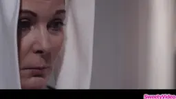 Strenge Nonne mit ernstem Blick in weißer Tracht schaut direkt in die Kamera
