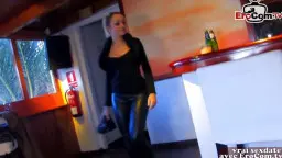 Dunkelhaarige Schönheit mit Pferdeschwanz und tiefem Ausschnitt lächelt verführerisch in einem Fastfood-Restaurant.