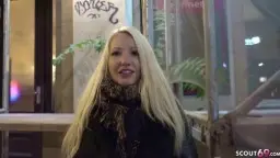 Blonde Frau mit Geld vor Hotel-Nachtszene
