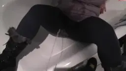 Rothaarige Frau sitzt mit Stiefeln auf weißer Toilette