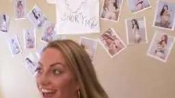 Blonde Frau lächelt vor Fotos an Wand